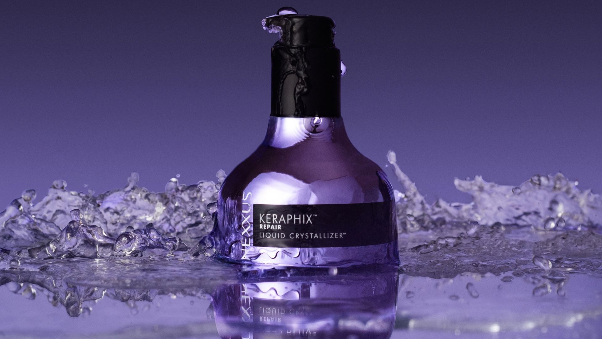Frasco de Nexxus Keraphix Repair Liquid Crystallizer rodeado por salpicos de água.