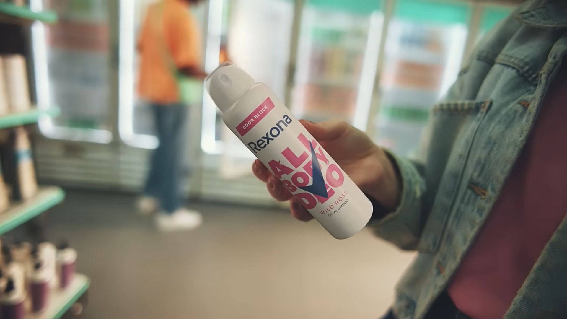 Uma pessoa segurando um frasco de Rexona All Body Deo com aroma de rosa silvestre.