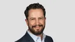 Foto de Leandro Barreto, Diretor de Marketing de Beleza e Bem-Estar da Unilever. Leandro é branco, tem cabelos escuros e barba e está sorrindo para a câmera.